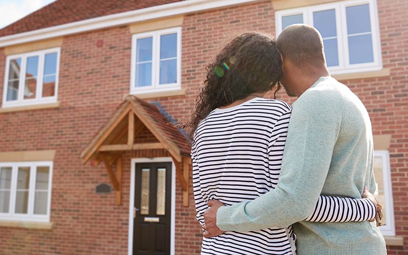 Couple looking at the outside of their new home